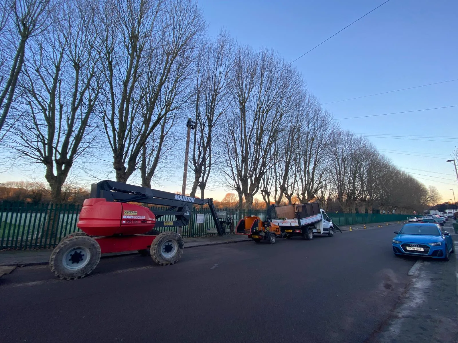 Cherry picker and wood chipper set up on a residential street ready for tree work